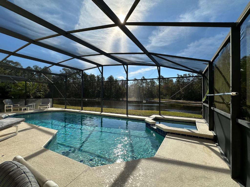 a large swimming pool with a glass roof at Sunny lake view villa with pool spa - close to attractions in Davenport