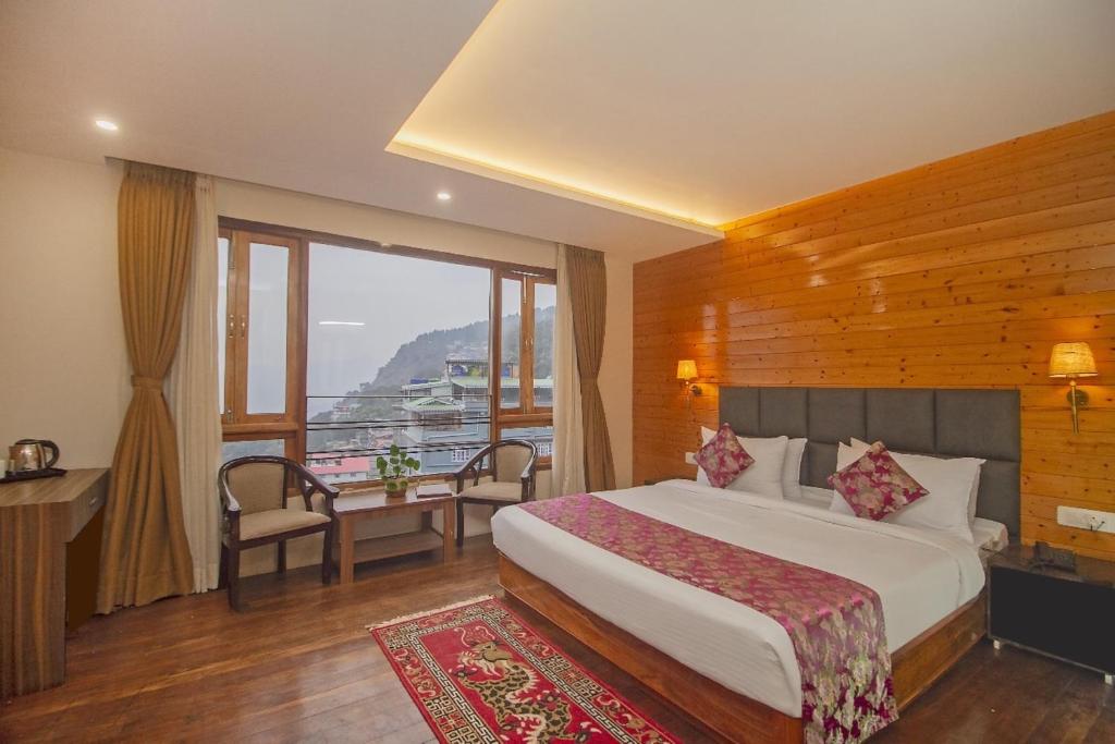 a hotel room with a bed and a balcony at Royal Hotel Gangtok in Gangtok