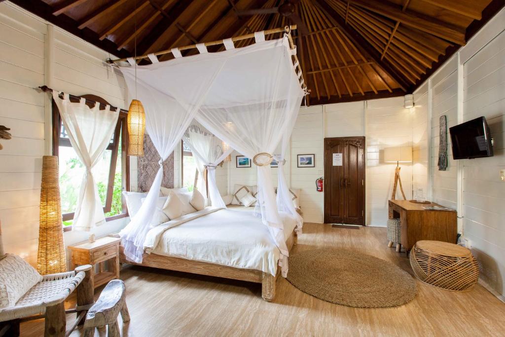 a bedroom with a bed with a canopy at Mondo Surf Village in Canggu