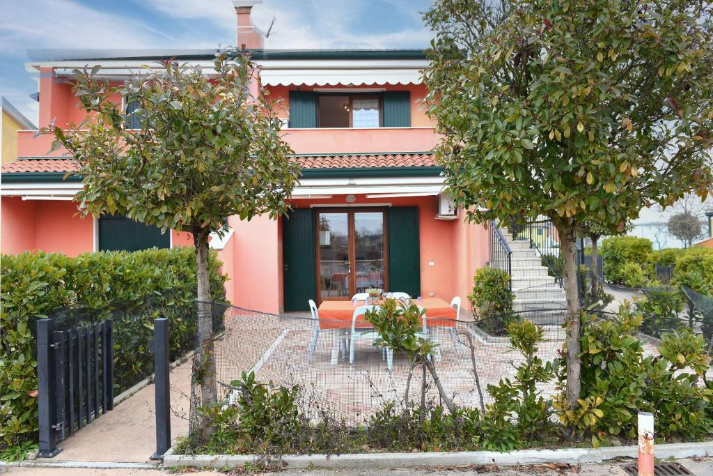 a house with a table and chairs in front of it at Villaggio dei Fiori in Caorle