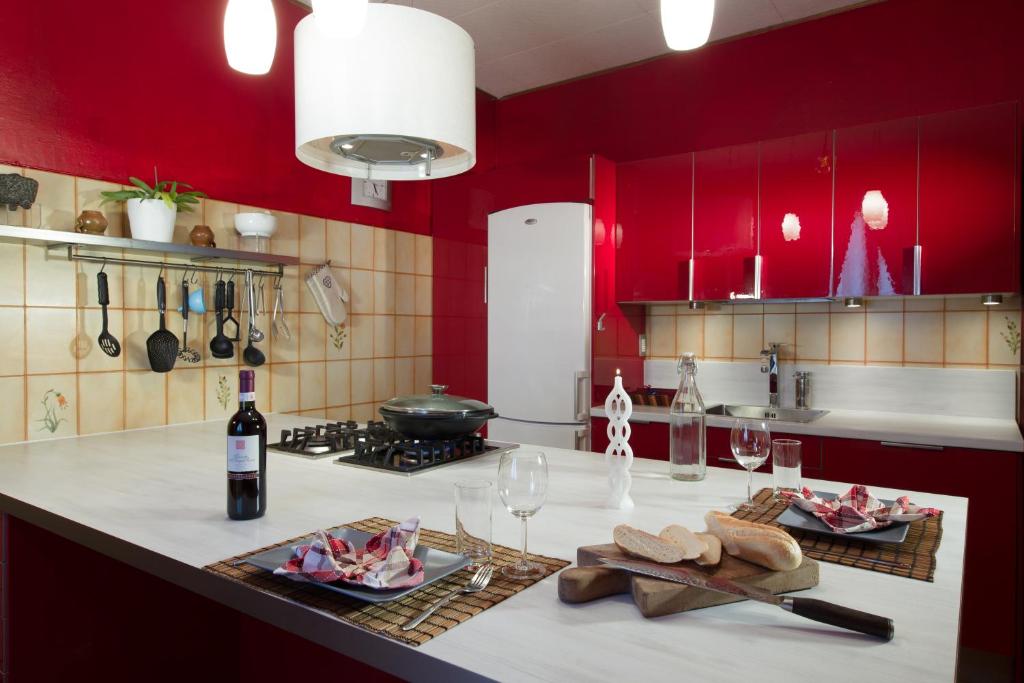 a kitchen with red walls and a counter with wine glasses at B&B Miele in San Fermo della Battaglia