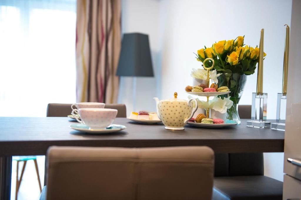 a table with a vase of flowers and tea cups at Rosaliya in Cochem