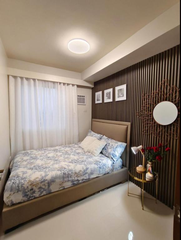a small bedroom with a bed and a window at JB Casa del Alivio in Butuan