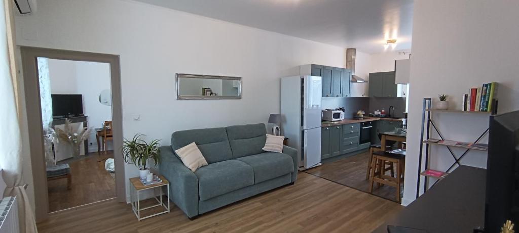 a living room with a couch and a kitchen at Le Havre de Sauge in Imphy