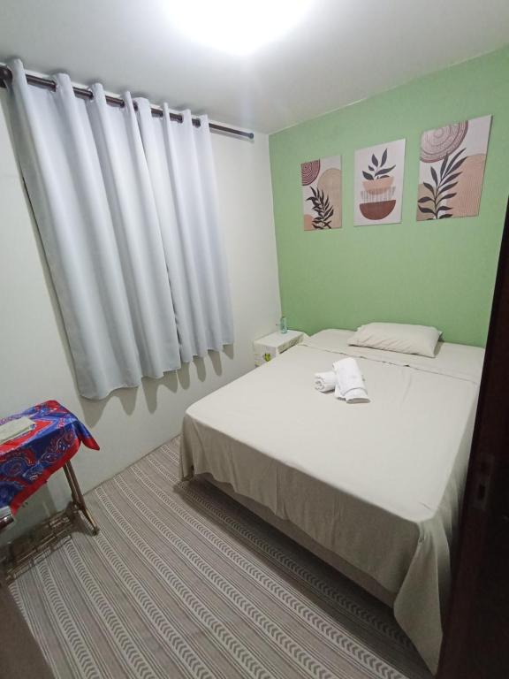 a bedroom with a white bed and a window at Casa Quarto 1 in Jaraguá do Sul