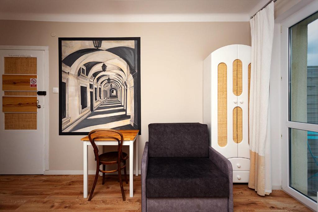 a living room with a chair and a picture on the wall at APARTAMENT 16 in Zamość