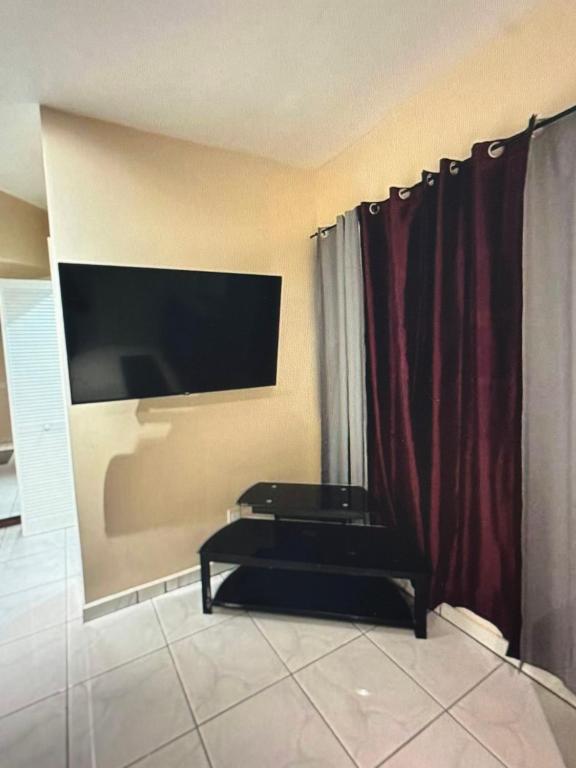 a living room with a flat screen tv and red curtains at Escape to paradise in Providenciales