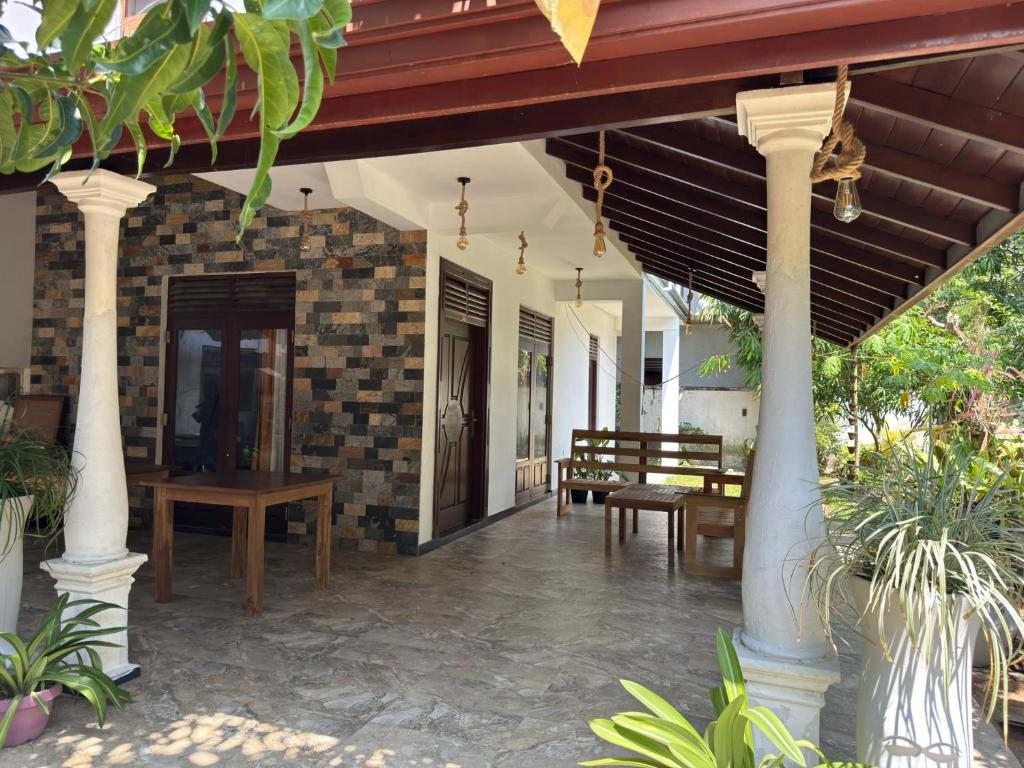 a porch of a house with chairs and a table at River Breeze Villa in Nikawatawana