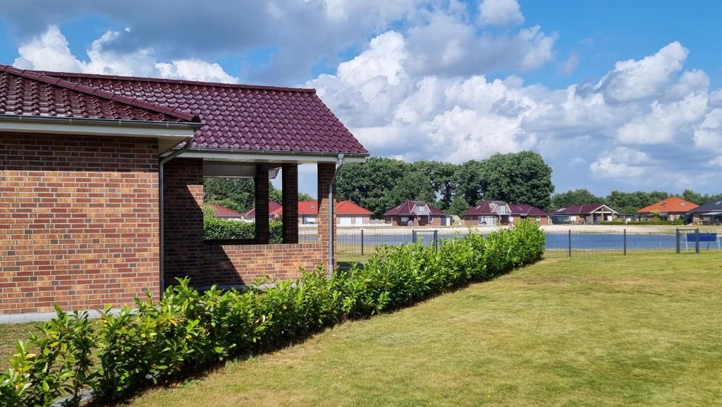 a brick building with a row of bushes at STRANDhaus Viktoria in Walchum