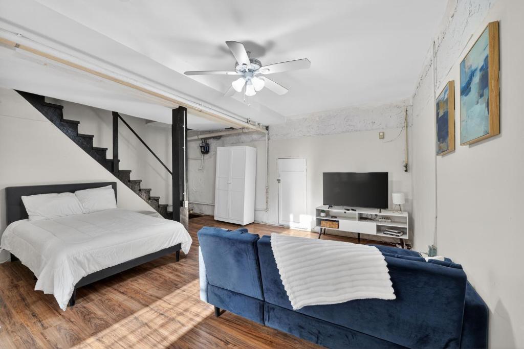 a bedroom with a bed and a blue couch at Cozy Baltimore Studio apts in Baltimore