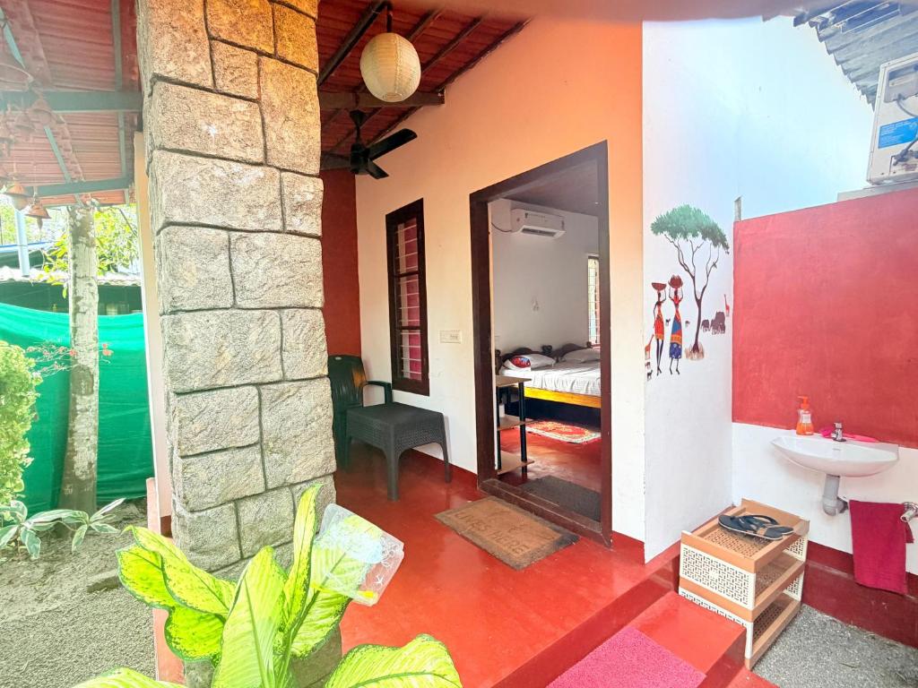 a house with a room with a sink and a bedroom at Marari Sabari Home Stay in Mararikulam