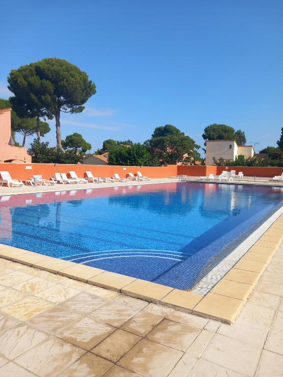 a large swimming pool with lounge chairs at Maisonnette les oliviers in Argelès-sur-Mer