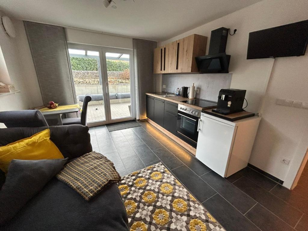 a living room with a couch and a kitchen at Ferienwohnung im Hasenwieschen in Kaisersesch