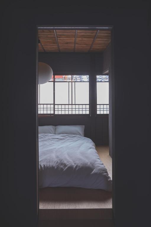 a bedroom with a bed in a room with a window at new tradition hotel kanazawa in Kanazawa