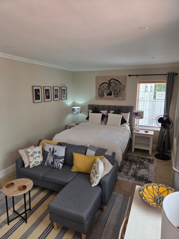 a bedroom with a bed and a couch at Striped Horse Guest House - Kenilworth Upper in Cape Town