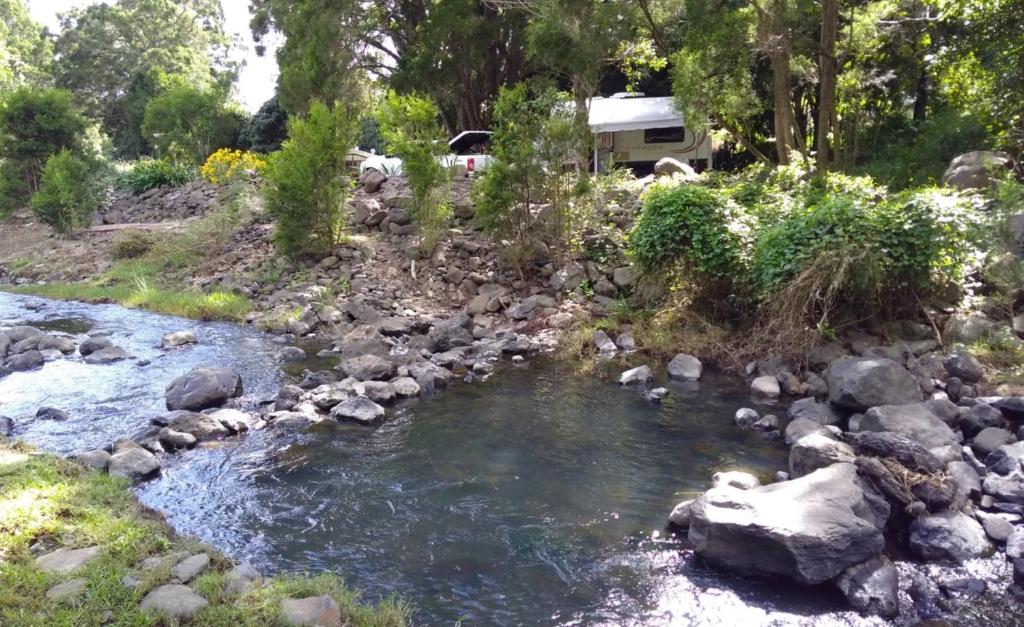 a river with rocks and a rv in the background at Giulia Guests Rooms in Beechmont