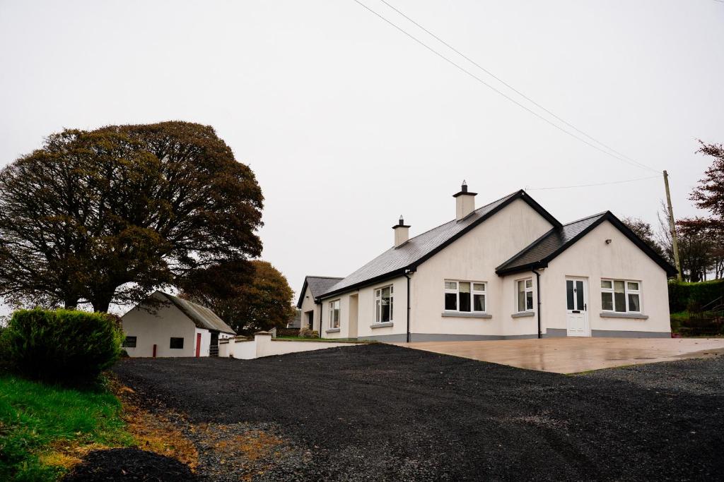 a white house with a driveway in front of it at Cairn view in Mountfield