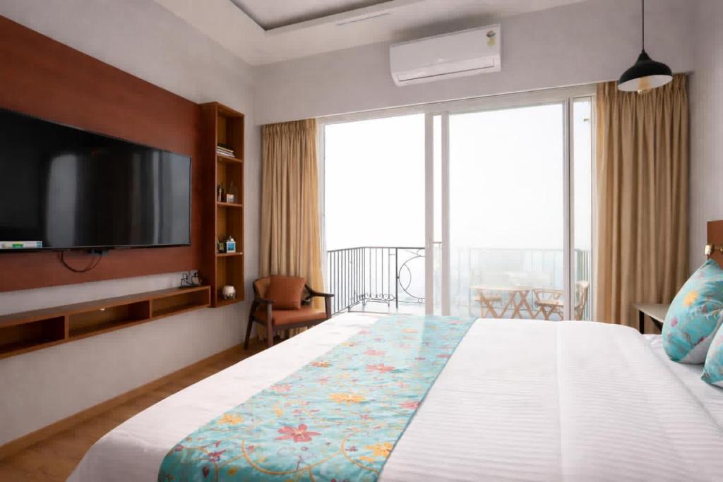 a bedroom with a large bed with a flat screen tv at Sunhaven Studio I Work & Leisure Stays I Near Expo Mart in Greater Noida