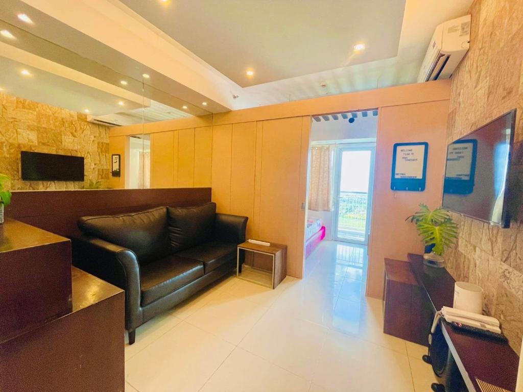 a living room with a black leather couch in a room at The Wind Escape Netflix-Ready Staycation for 4 in Tagaytay