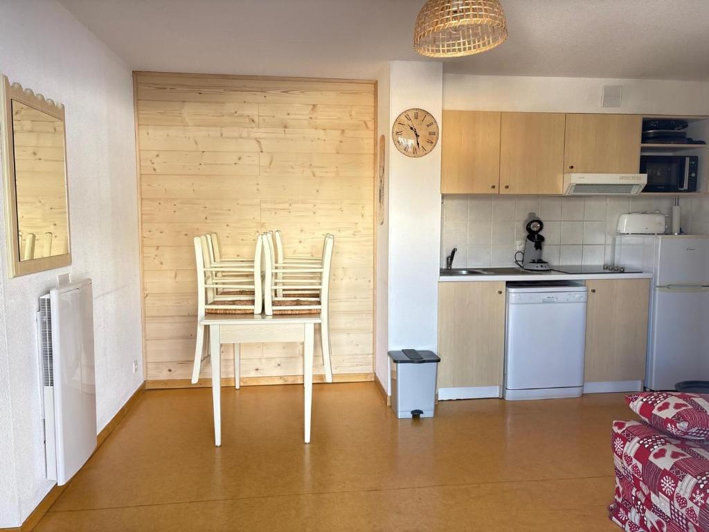 a kitchen with a table and chairs in a room at Appartement Les chalets de Puy-St-Vincent 1700 in Puy-Saint-Vincent