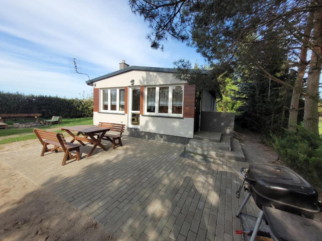 a small house with a picnic table and benches at Domek nad Gopłem in Połajewek