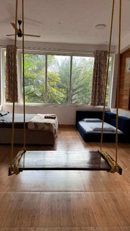 a bedroom with two beds and a swing at Wooden Villa in Kanchipuram