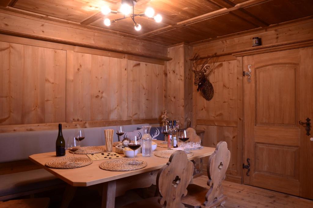 a wooden dining room with a table with chairs and wine bottles at Beim Patzelt - Ferienhaus in Nesselwang in Nesselwang