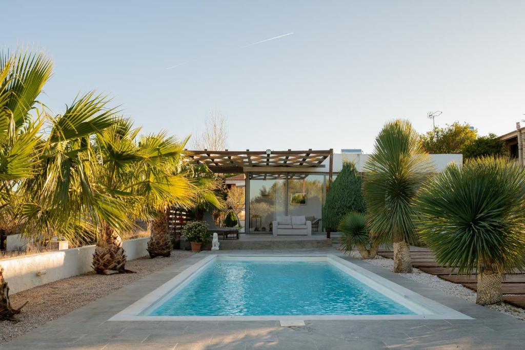 a swimming pool in a yard with palm trees at Villa Tata - Private Pool, Garden & Mountain View near the Sea in Metókhi
