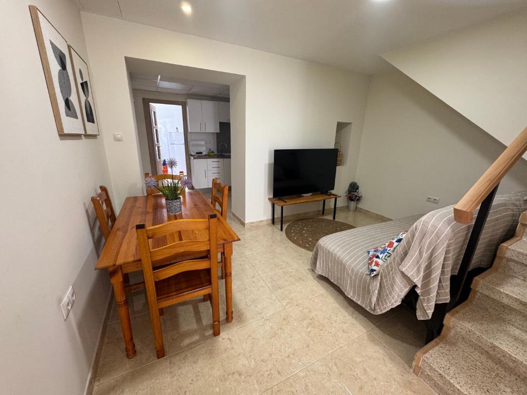 a living room with a dining room table and a television at Casa Alan in Burriana