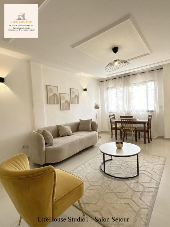 a living room with a couch and a table at Residence Life House Makepe bm in Douala