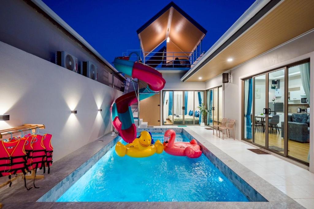 a swimming pool with a slide in a house at You Baan Pool Villa Cha-am in Ban Bo Prakhon