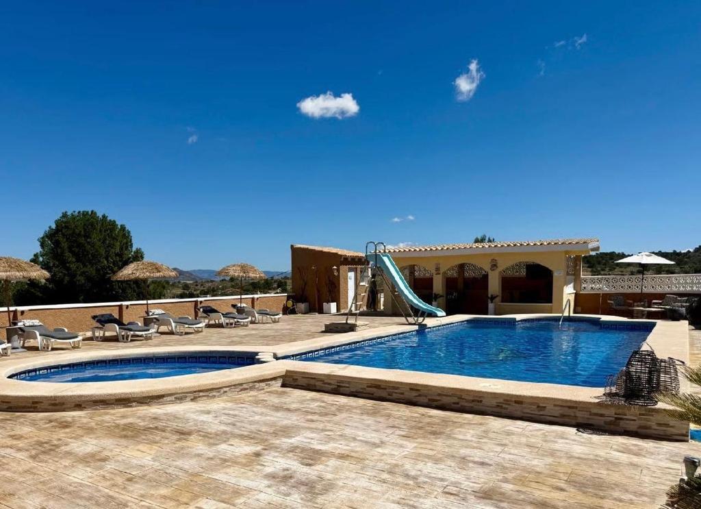 a swimming pool with a slide in a resort at Casa Duseña Luna in Hondón de las Nieves
