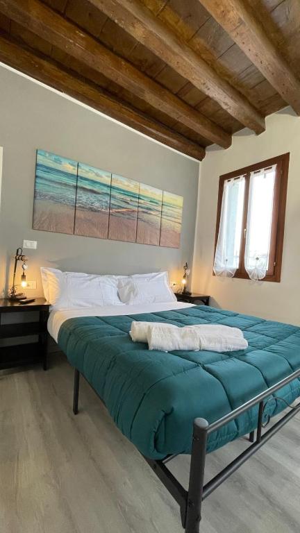 a bedroom with a large bed with blue sheets at Frida Apartment in Chioggia