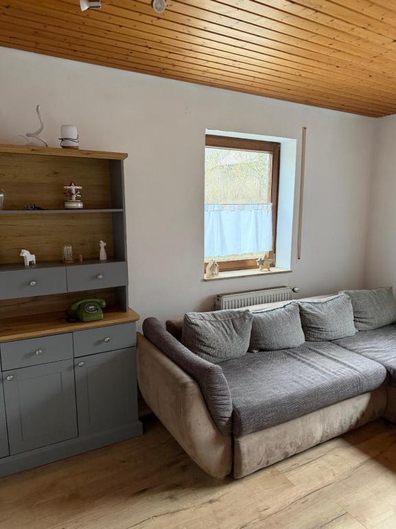 a living room with a couch and a window at Ferienwohnung Landleben in Bühlertann