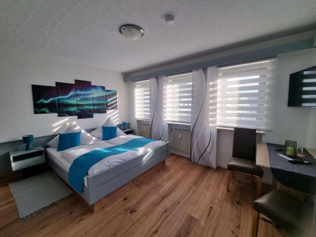 a bedroom with a bed and a desk and windows at Stadtblick Bischofsheim in Bischofsheim an der Rhön