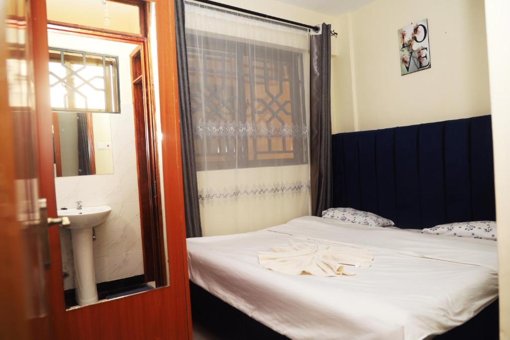 a bedroom with a bed and a sink and a window at PALISADES homes in Voi