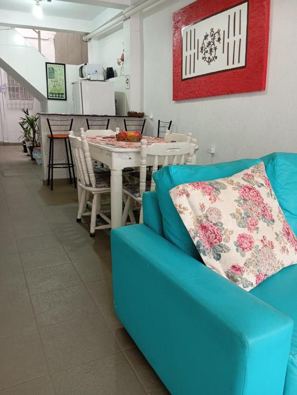 a living room with a blue couch and a table at Pousada Hostel Brasil Gru in Guarulhos