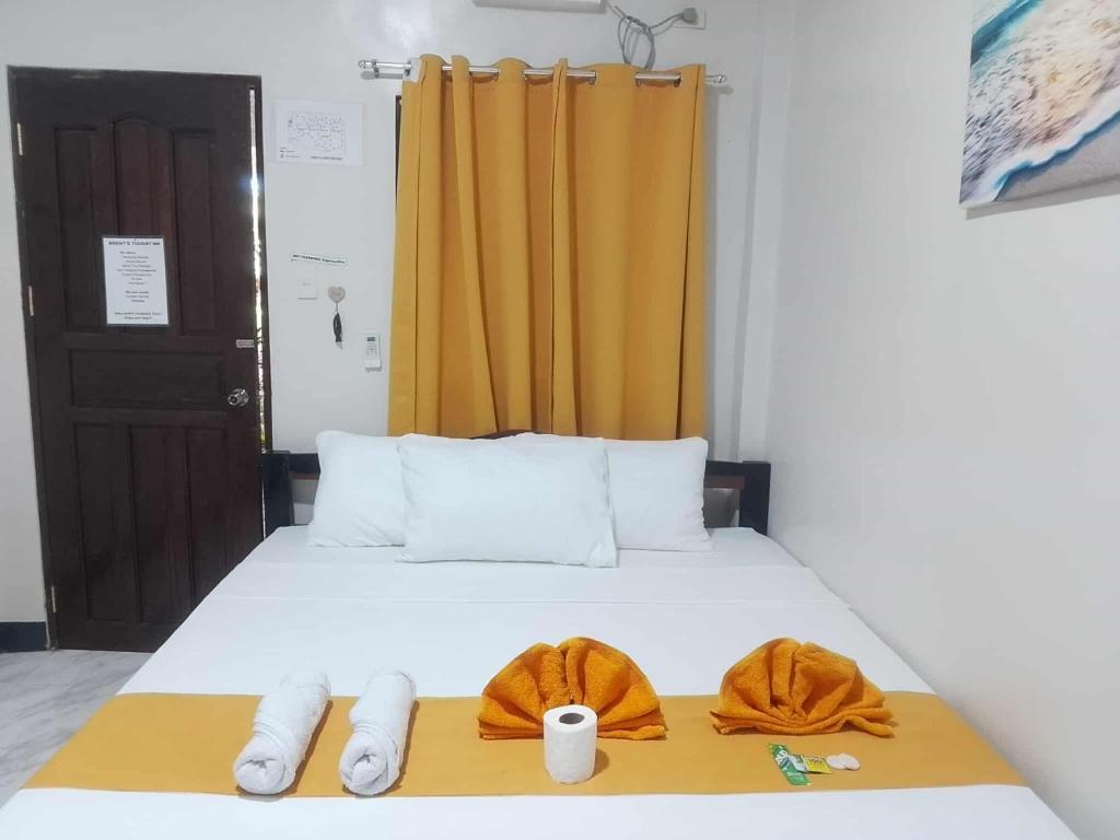 a bedroom with a bed with two towels on it at Brent's Tourist Inn in Itaytay