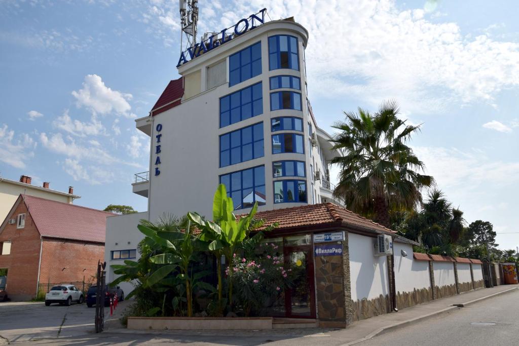 um edifício alto com um sinal em cima em Hotel Avallon em Adler