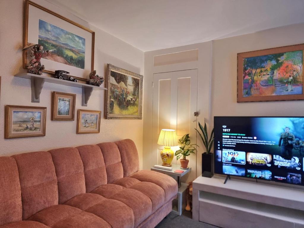 a living room with a couch and a flat screen tv at Canterbury within the city wall - Sleeps 7 - Pet-Friendly with Garden in Canterbury