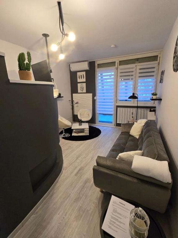 a living room with a couch and a tv at Ákos Apartman in Székesfehérvár