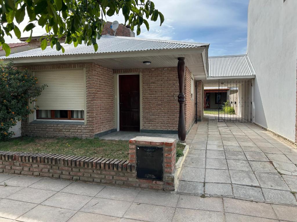 a brick house with a front porch and a driveway at La 22 in Balneario Claromecó
