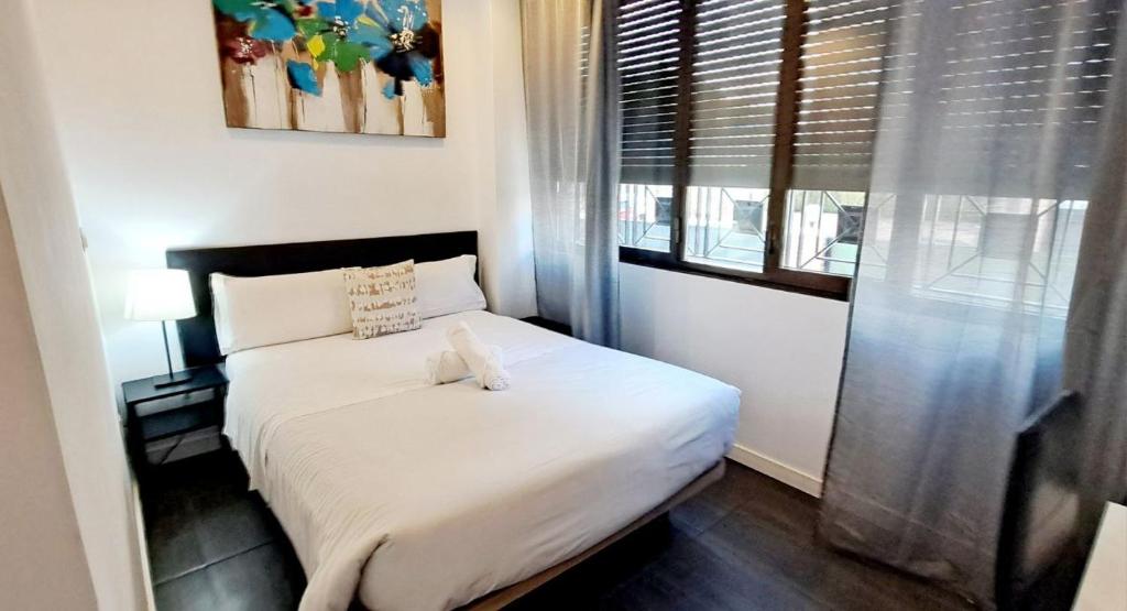 a bedroom with a white bed with a window at AYZ Ulises - Auto check-in property in Madrid