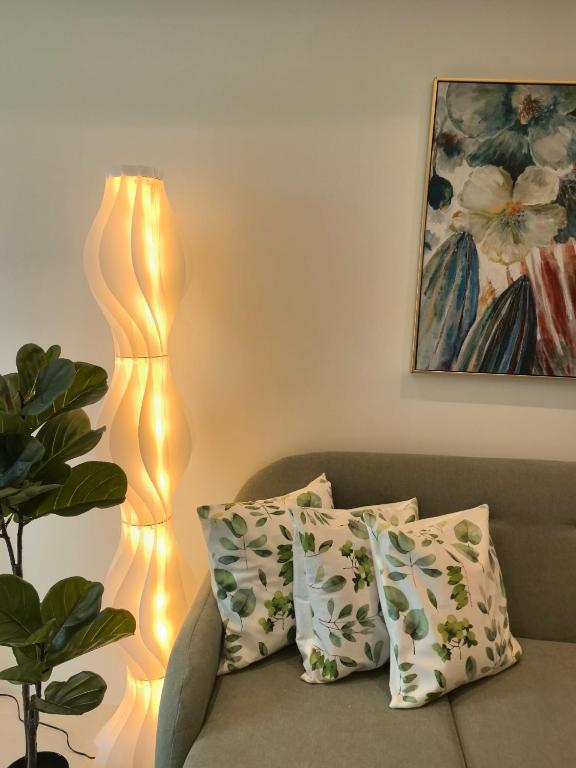 a lit up lamp sitting next to a couch at One Bedroom with Balcony in Abreeza Mall in Davao City