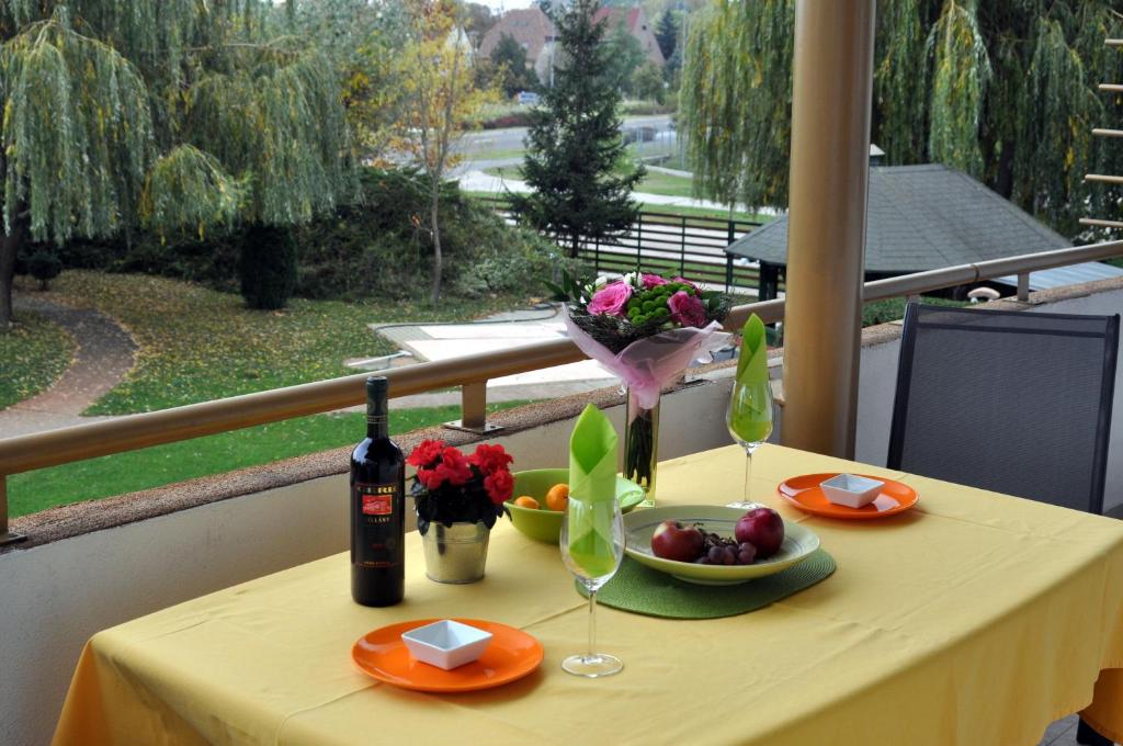 uma mesa com uma garrafa de vinho e um prato de fruta em gyorapartman2 em Gyor