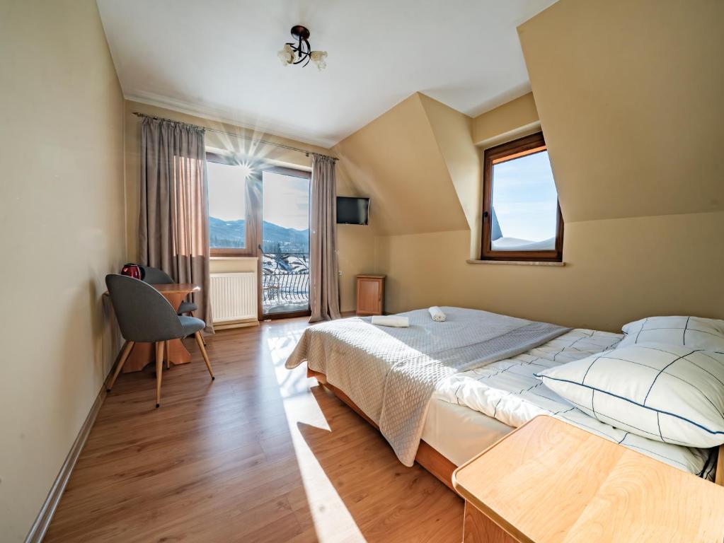 a bedroom with a large bed and a large window at Willa TOSKA in Murzasichle