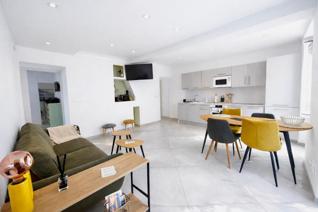a living room and kitchen with a couch and a table at Appartement T3 Place du Marché in Bastia