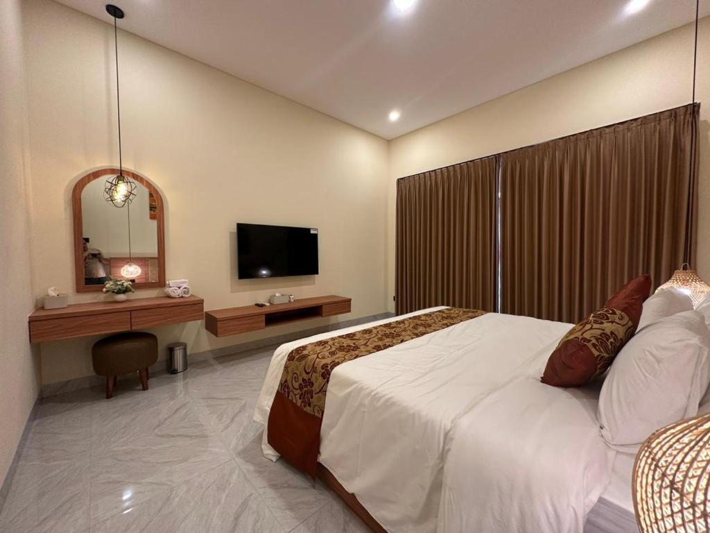 a bedroom with a large bed and a television at Golden Villa Lovina in Lovina