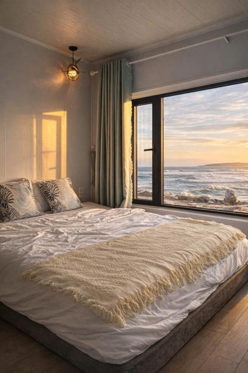 a bedroom with a large bed with a view of the ocean at Long Vĩ hotel - đảo Phú Quý in Cu Lao Thu