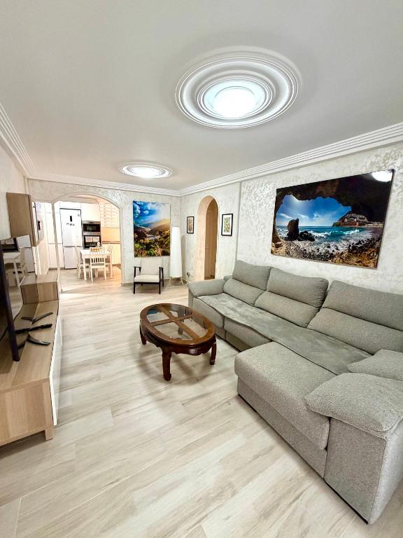 a living room with a couch and a table at Cozy Garden by the Beach in Playa del Cura